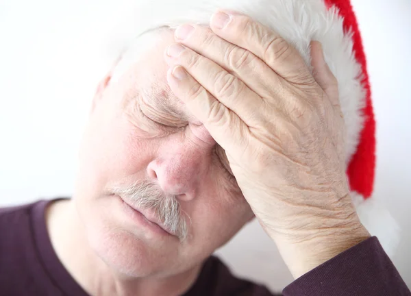 Man wearing Santa hat with headache — Stock Photo, Image