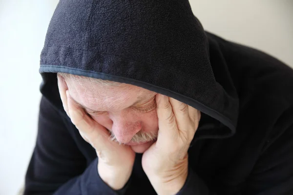 Sad older man in hooded jacket — Stock Photo, Image