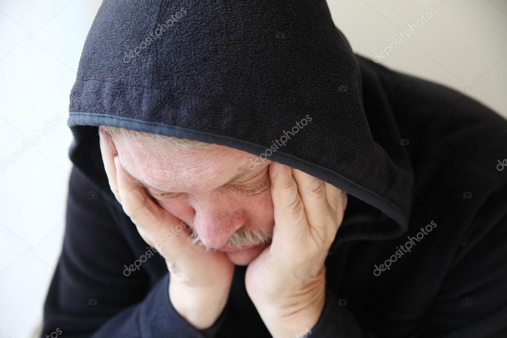 Sad older man in hooded jacket