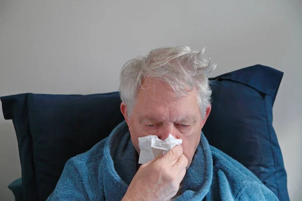 Sick Older Man Holds Tissue His Nose Leaning Pillow Royalty Free Stock Images