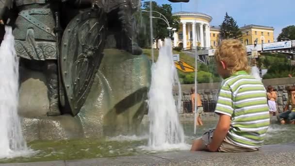 Jongen spatten water bij fontein — Stockvideo