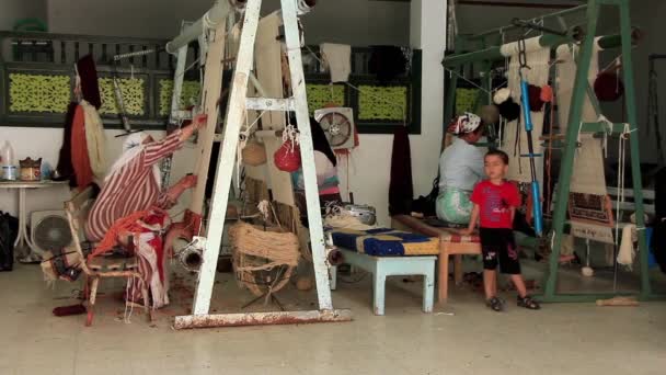 Ковроткачество. Три женщины, берберы, ковроткачество. Ткацкая фабрика в Тунисе — стоковое видео