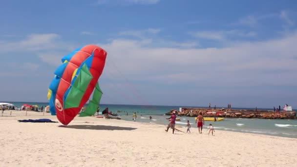 Parasailing. färg fallskärm på stranden — Stockvideo