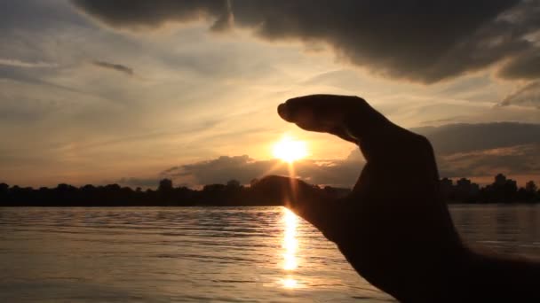 Рука ловит солнце в кулак — стоковое видео