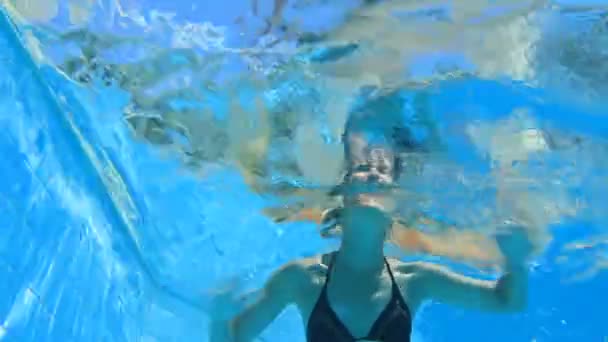 Mujer joven buceando en una piscina — Vídeo de stock