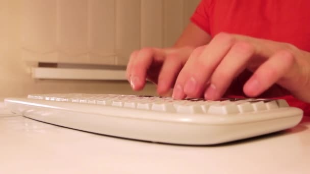 Un homme tapant avec un clavier d'ordinateur 