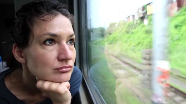 Γυναίκα κάθεται στο τρένο κοντά σε παράθυρο κατά την κίνηση — Αρχείο Βίντεο