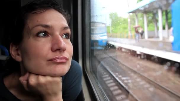 Woman sits in train near window during movement — Stock Video