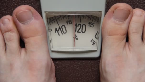 Controle van iemands gewicht op een schaal — Stockvideo