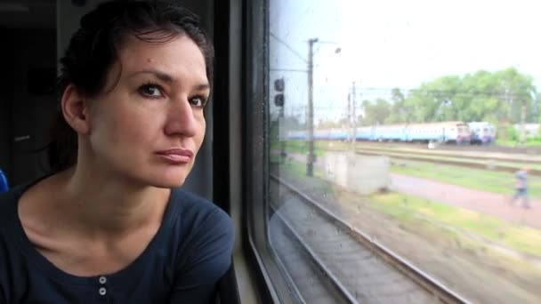 Vrouw zit in trein in de buurt van venster tijdens beweging — Stockvideo