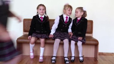 Üç kız okulu bankta oturmuş