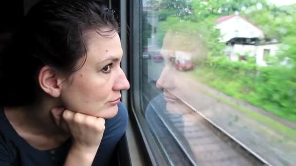 Woman sits in train near window during movement — Stock Video