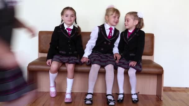 Tres chicas sentadas en un banco de la escuela — Vídeo de stock