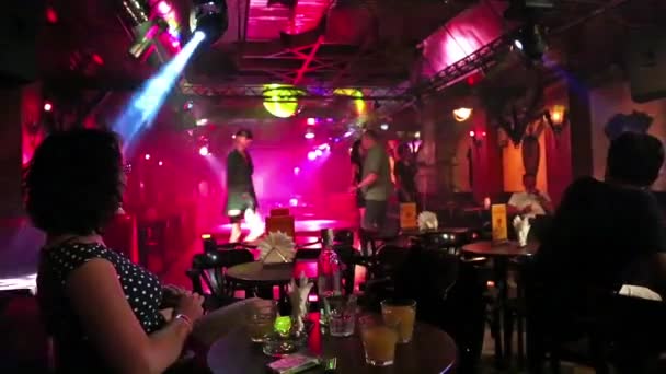 Vrouw zit aan een tafel in een discotheek — Stockvideo