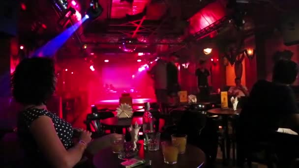 Woman sits at a table in a nightclub — Stock Video