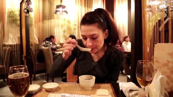 Женщина ест мисо-суп в японском ресторане — стоковое видео