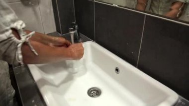 Kadın ellerini yıkar.