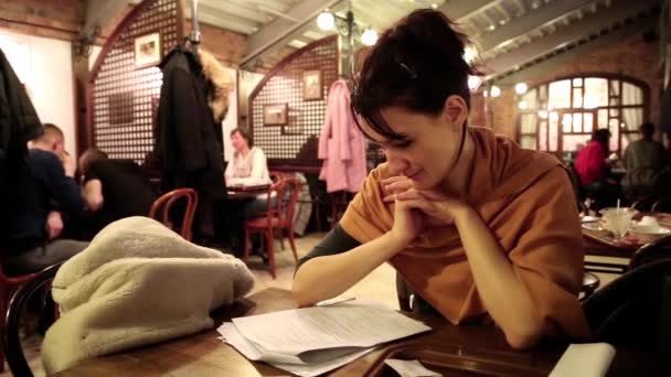 Женщина читает в ресторане — стоковое видео