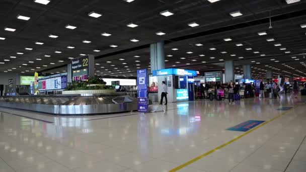 Ludzie wewnątrz hali przyjazdu na międzynarodowym lotnisku w bangkok, Tajlandia — Wideo stockowe