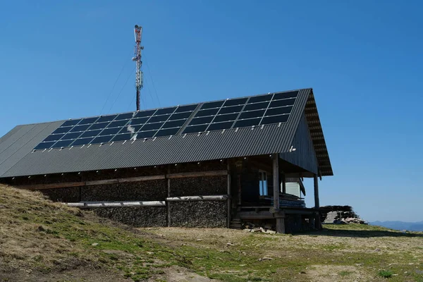 Panele Ogniw Słonecznych Dachu Drewnianego Domu Wieży Komórkowej Górach — Zdjęcie stockowe