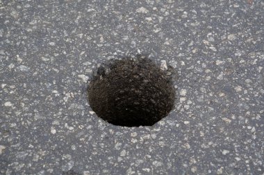 Yol kalitesini kontrol etmek için asfalttaki yuvarlak delik