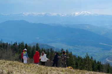 CARPATHİan Dağları, UKRAINE, 12 Mayıs 2021: Bir grup insan, karla kaplı güzel dağlara bakan Polonyna Borzhava sıradağları üzerinde meditasyon yapıyor.