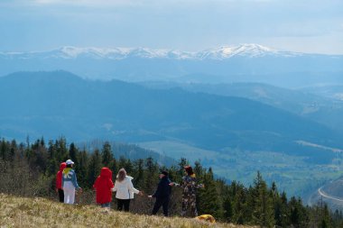 CARPathan Dağları, UKRAINE, 12 Mayıs 2021: Bir grup insan, karla kaplı güzel dağlara bakan Polonina Borzhava sıradağları üzerinde meditasyon yapıyor.