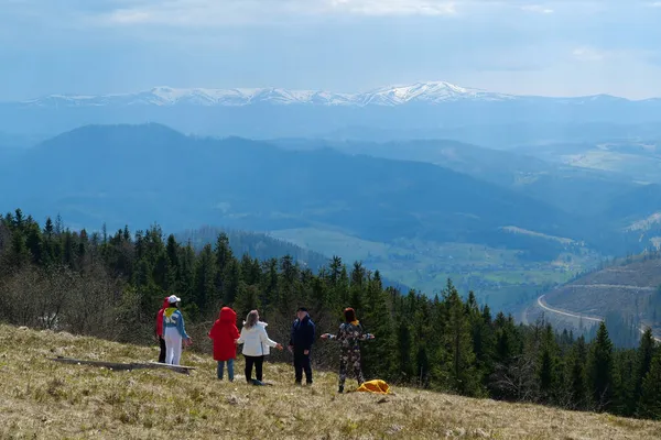 CARPATHİan Dağları, UKRAINE, 12 Mayıs 2021: Bir grup insan, karla kaplı güzel dağlara bakan Polonyna Borzhava sıradağları üzerinde meditasyon yapıyor.