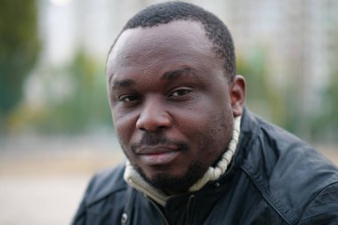 Nijeryalı Afrikalı Amerikalı adam kameraya bakıyor.