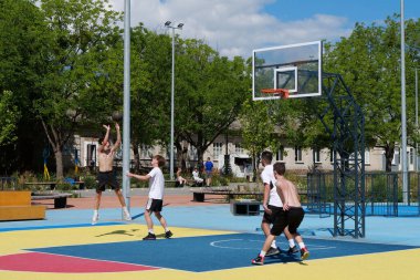 KYIV, UKRAINE, 26 Temmuz 2022: Gençler Ukrayna 'nın Kyiv, Ukrayna' nın Teremky semtindeki çok amaçlı kalıcı sergi kompleksi Expocenter 'daki yeni açık hava spor sahasında sokak basketbolu oynuyorlar.