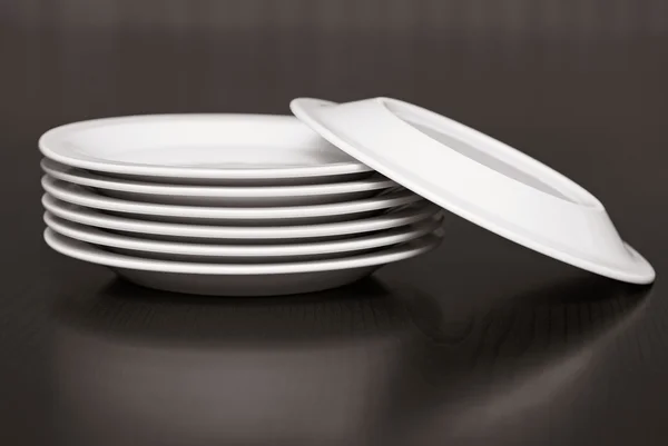 Стопка белых тарелок на столе — стоковое фото