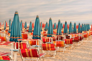 içine kapanık şemsiye ve sunlongers İtalya kumlu plaj