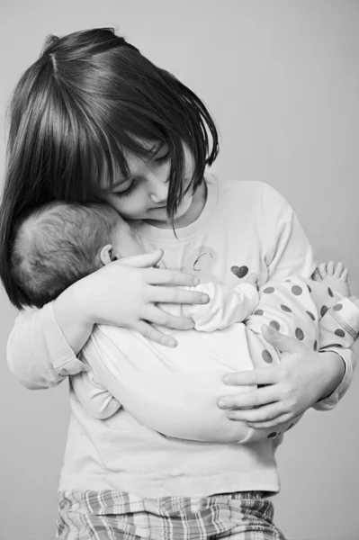 Gelukkig meisje houdt van haar pasgeboren zus — Stockfoto