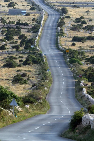 Asfalt kronkelende weg, eiland van pag, Kroatië. — Stockfoto