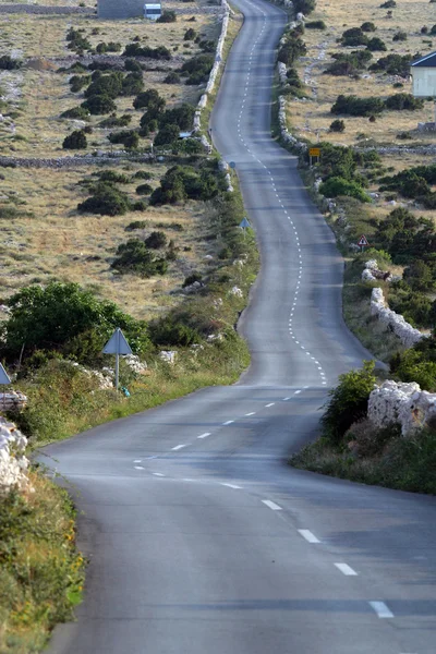 Asfalt kronkelende weg, eiland van pag, Kroatië. — Stockfoto