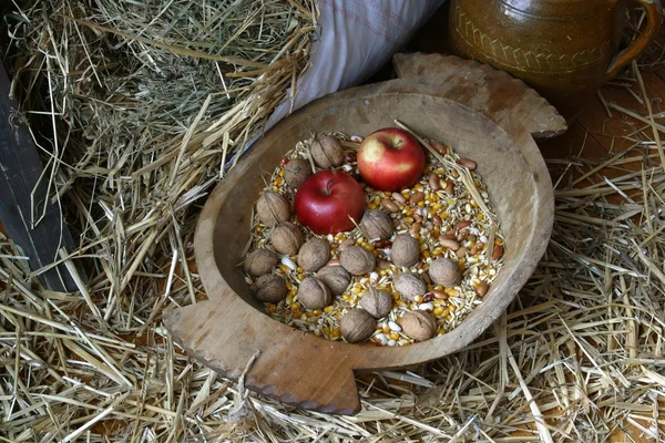 An apple and walnuts in an old wooden basket — Stock Photo, Image