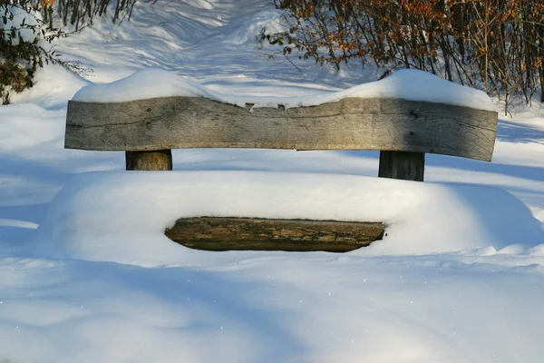 Banco de madeira coberto com neve — Fotografia de Stock