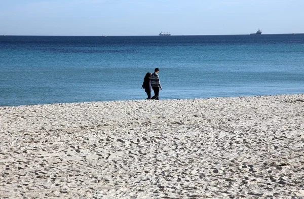 Casal caminhando na praia aproveitando as férias — Fotografia de Stock