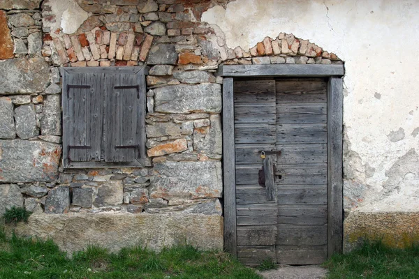 Wooden door and window, on stone facade. — Stock Photo, Image