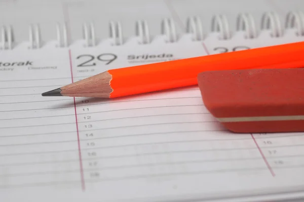 Pencil and eraser laying on spiral notebook or notepad — Stock Photo, Image