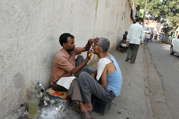 Barbiere di strada radere un uomo in una strada a Calcutta, West Bengal, India — Foto Stock