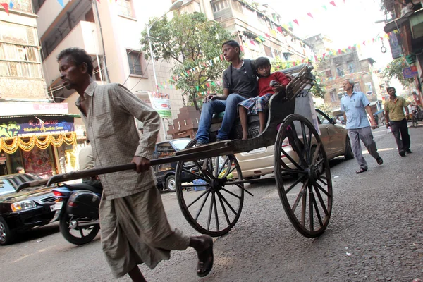 Rickshaw hombre tira del cliente en las calles de Calcuta, India — Foto de Stock