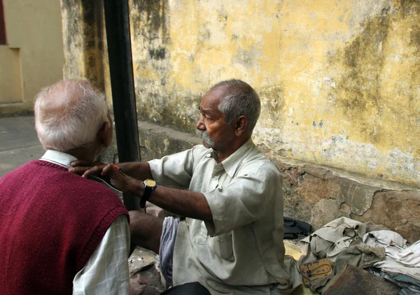 Street barber shaving a man on a street in Kolkata — Stock Photo, Image