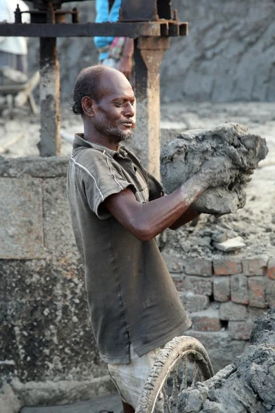 Ziegelfeld. Arbeiter tragen abgelagerte Erde zur Herstellung von Rohsteinen — Stockfoto