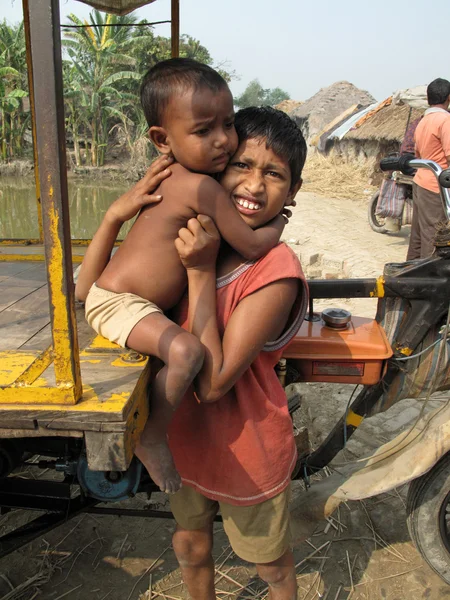 Hermana sosteniendo a su hermano pequeño en una remota aldea en Sundarbans, Bengala Occidental, India — Foto de Stock
