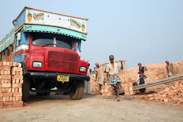 Trabajadores de campo de ladrillo llevando ladrillo acabado completo del horno, y lo cargó en un camión — Foto de Stock