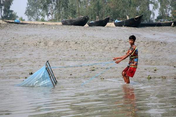 Pescador usa rede de pesca de uma forma tradicional para a pesca em um rio Ganges em Gosaba, Bengala Ocidental, Índia . — Fotografia de Stock
