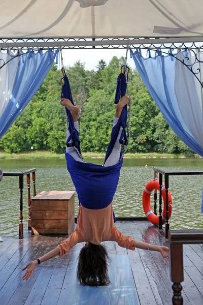 女人执业瑜伽锻炼在一张吊床户外 — 图库照片