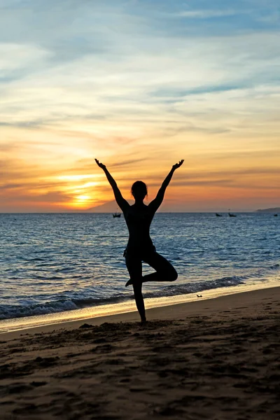 Silhouette woman practicing yoga on sunset — Stock Photo, Image