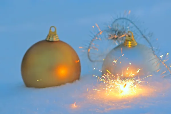 Bengal light and christmas balls in snow — Stock Photo, Image